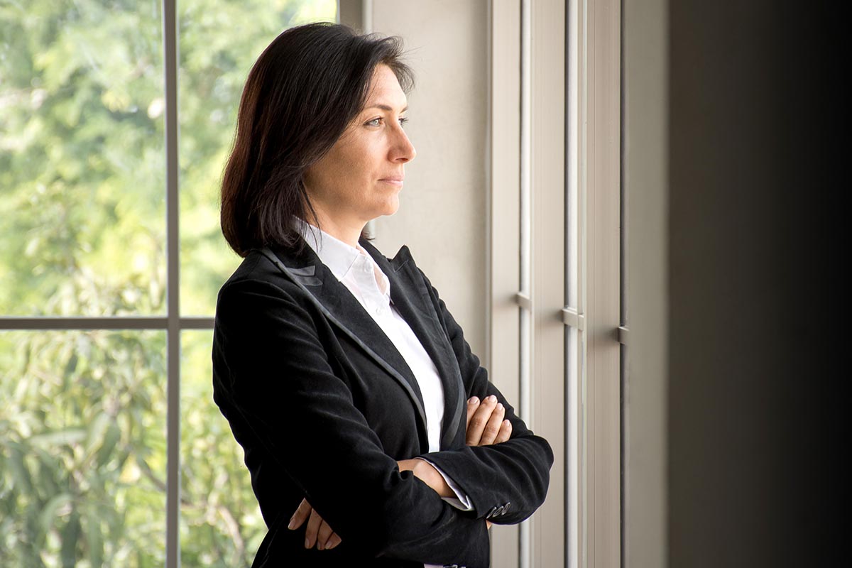 a woman stares out the window as she considers seasonal depression and seasonal affective disorder or sad before enrolling in a depression treatment program