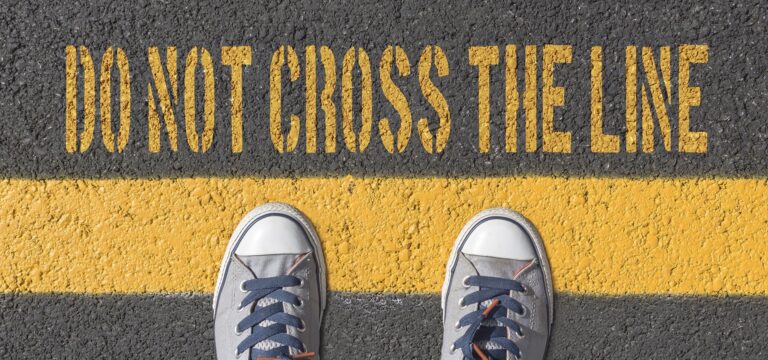 a person stands on a yellow line representing 5 boundaries you should be setting with the addict or alcoholic in your life