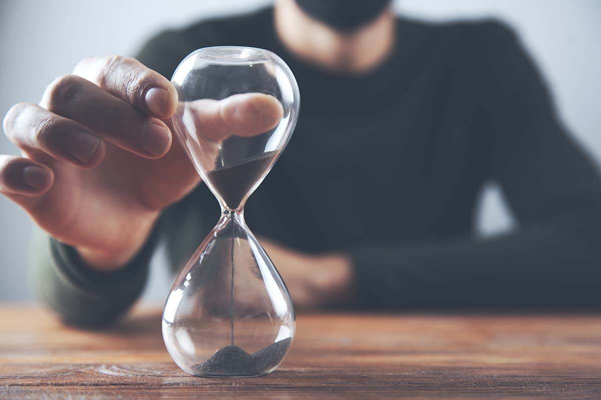 a person turns an hourglass and wonders how to practice patience