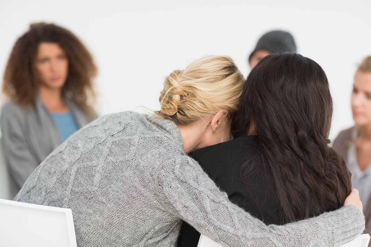 a woman hugs a friend after convincing her to enter drug rehab to prevent drug overdose